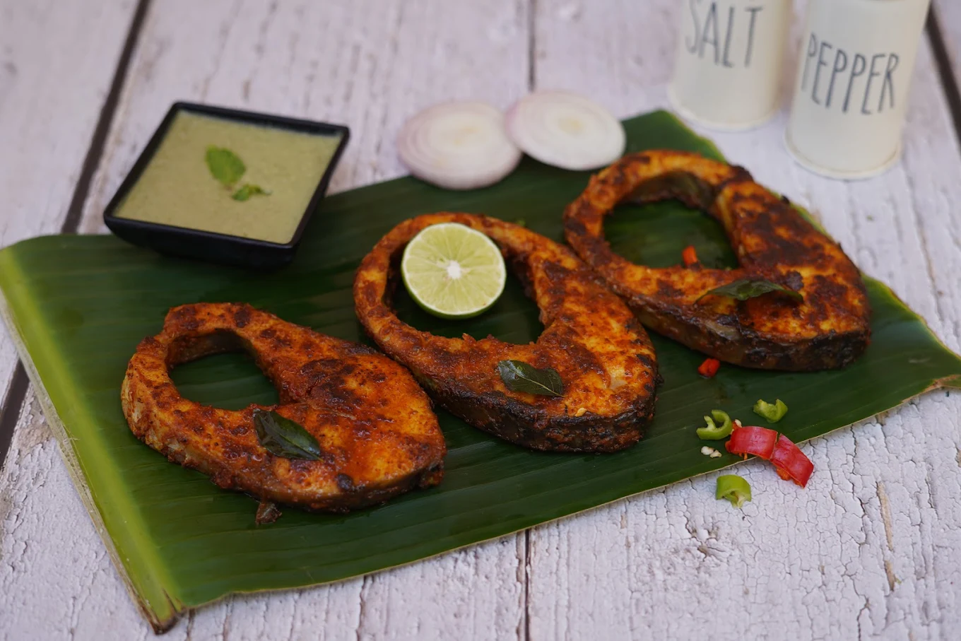 Spiced fish steaks served on a banana leaf